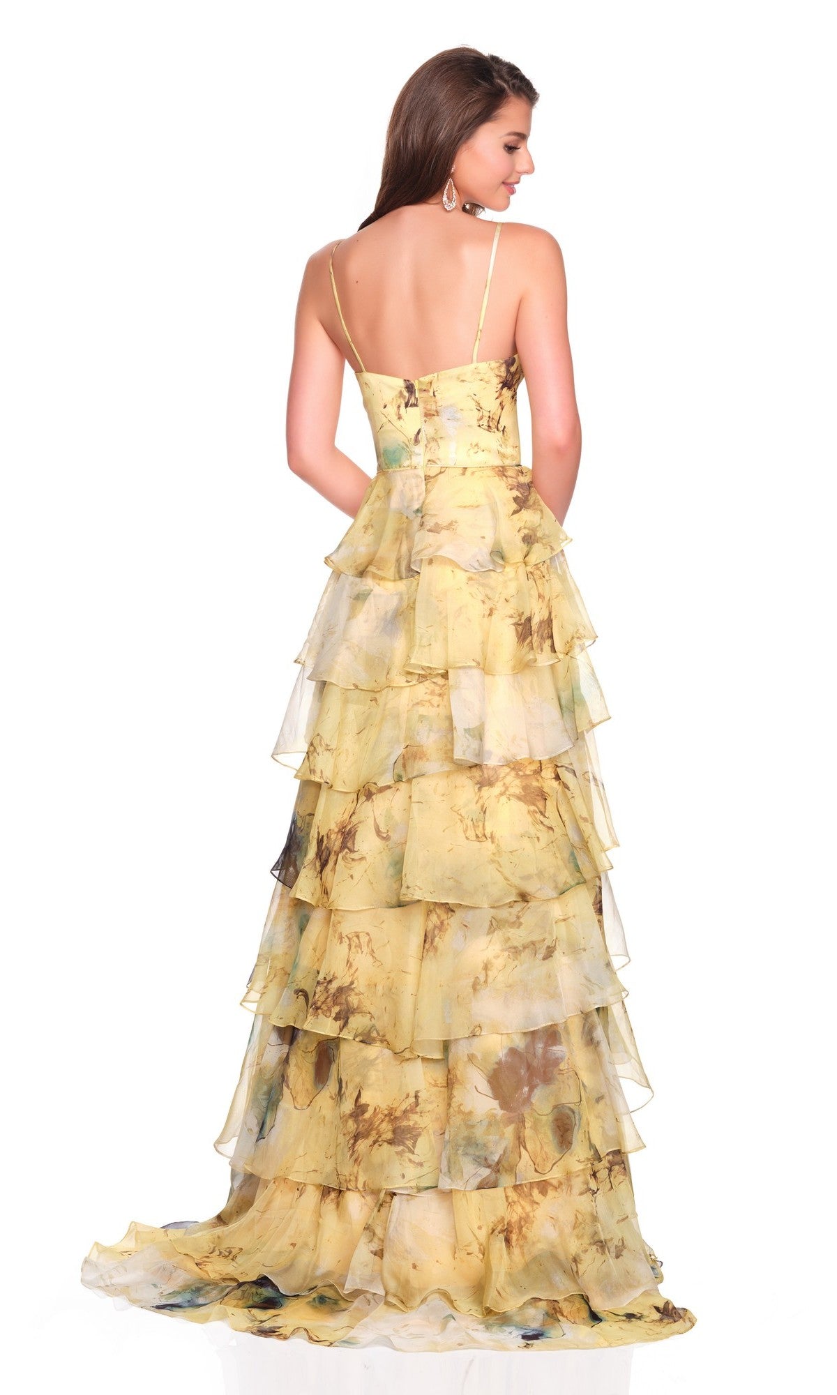 A woman faces away from the camera in the Dave and Johnny 12792 long prom dress, featuring thin straps and a floor-length, tiered chiffon a-line skirt with floral accents.